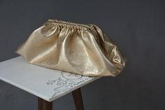 Introducing our luxurious Gold genuine Metallic leather dumpling cloud clutch, a statement accessory that exudes elegance and sophistication. This Large metallized lambskin cloud bag is perfect for those who love to make a bold fashion statement. With its oversized puffball design, this handbag purse is sure to turn heads wherever you go. Crafted with high-quality materials and intricate detailing, this clutch is a must-have for any fashion-forward individual looking to elevate their style game. Metallic Clutch Bag, Bags 2024, Metallic Clutch, Cloud Bag, Folding Bag, Evening Outfits, Leather Clutch Bags, Soft Tops, Manado