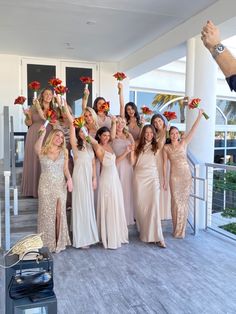 a group of women standing next to each other on top of a wooden floor holding bouquets