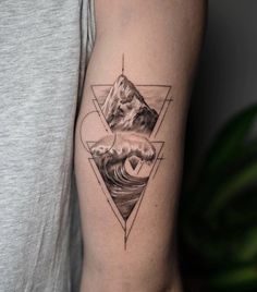 a man's arm with a mountain, wave and triangle tattoo design on it