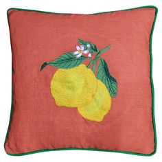 an embroidered pillow with two lemons on the front and green leaves on the back