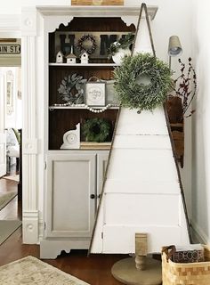 a white hutch with wreaths and other items on it