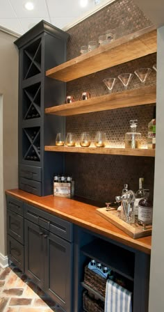 a kitchen with wooden shelves and glassware on the counter top, along with other items