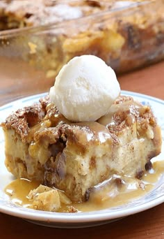 a piece of bread pudding with ice cream on top sitting on a white and blue plate