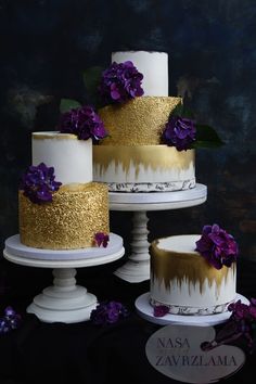 three tiered cakes with gold and white frosting, purple flowers on each one