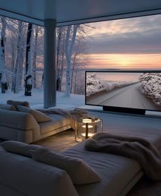 a living room with couches and a large flat screen tv on the wall in front of it