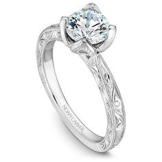 a white gold engagement ring with an intricate filigreet design on the band