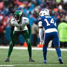 two football players are on the field during a game, one is wearing green and white