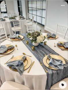 the table is set with silver and gold plates, napkins, and place settings