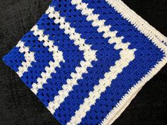 a blue and white crocheted dishcloth on a black surface