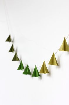 green and gold paper christmas trees hanging on a string