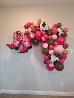 the balloon wall is decorated with cowgirl boots and balloons