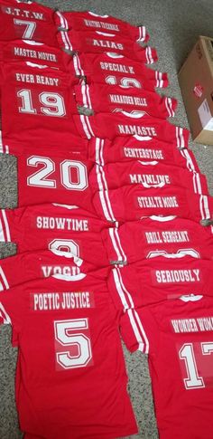 red shirts with white numbers are laid out on the floor