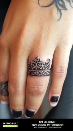 a woman's hand with a tattoo on it and a tiara ring in the middle