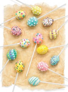 there are many cake pops with sprinkles on the stick in front of them