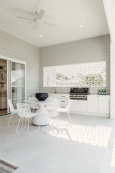 a white table and chairs are in the middle of a room with sliding glass doors