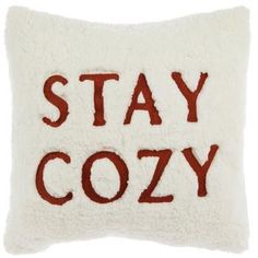 a pillow with the words stay cozy written in red and white on it's side