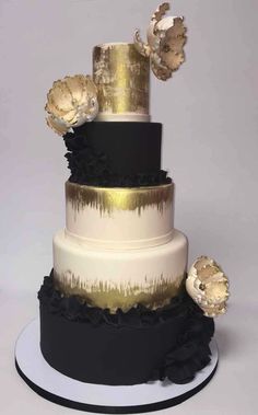 a three tiered cake with black and gold decorations