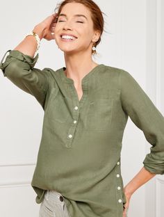 Our easy popover top is a seasonal favorite. Airy linen keeps you cool even on hot days. Features a sleek band collar and buttoned half-placket. Roll the sleeves up or wear them down. Pop this style over your favorite jeans or shorts. Features Long Sleeve Hits Below Hip Band Neck Pullover Patch front pockets Curved shirttail hem Imported Fit: Misses: 28 1/4"; Petite: 26 1/4"; Plus: 30 3/4"; Plus Petite: 28 3/4" Material: 100% Linen Care: Machine Wash Cold; Only Non-Chlorine Bleach When Needed; Tumble Dry Low; Cool Iron, If Needed | Side Button Linen Band Collar Popover Shirt Talbots Spring Henley Neckline Top With Placket, Casual Linen Tops With Button Cuffs, Casual Split Neck Top With Placket, Casual Split Neck Top With Buttons, Versatile Summer Tops With Button Cuffs, Linen Henley Neckline Tops For Summer, Summer Linen Tops With Henley Neckline, Linen Tops With Henley Neckline For Summer, Green Linen Tops With Placket