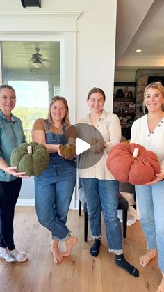 four women holding stuffed animals in their hands and smiling at the camera while standing in a living room