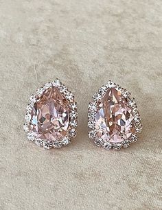 Gorgeous pair of earrings featuring 14x10mm pear cut Swarovski crystals in a lovely morganite pink color surrounded by a halo of sparkling clear crystals. Rose gold metal finish. Thanks for stopping by. Pink Teardrop Jewelry With Halo Setting, Pink Teardrop Bridal Earrings For Party, Pink Rhinestone Earrings In Cubic Zirconia, Pink Sparkling Earrings For Anniversary, Pink Pear-shaped Earrings For Anniversary, Pink Teardrop Earrings For Anniversary, Anniversary Pink Sparkling Earrings, Pink Jewelry With Halo Setting For Party, Pink Halo Setting Jewelry For Party