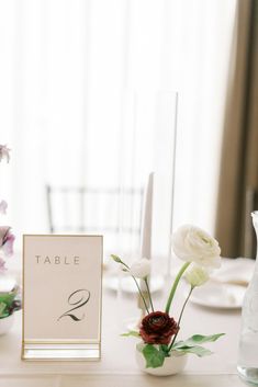 the table is set with flowers and place cards