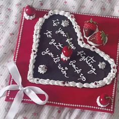 a heart shaped birthday cake with strawberries on it