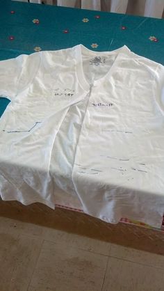 a white shirt sitting on top of a wooden table next to a blue cloth covered box