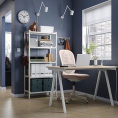 an office with blue walls, white furniture and a clock on the wall above it