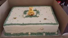 a birthday cake in the shape of a box with a dog on top and bees around it