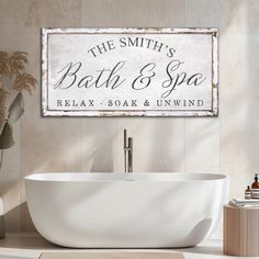 a bath and spa sign hanging on the wall next to a white tub in a bathroom