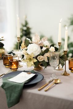 the table is set with candles, plates and napkins for an elegant wedding reception