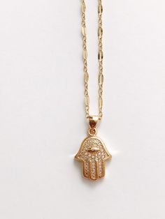 "A beautifully detailed Cz Pave Hamsa Hand on 18\" sparkly gold filled chain. 0.75\" in size. The Hamsa aka the Hand of Fatima is a protective amulet that brings good fortune, health and happiness. Sold individually, all other necklaces available on the website. Return to shop: Afrohemien.etsy.com Like and Follow Afrohemien for updates, sales, coupons and surprise giveaways Instagram/Blog: instagram.com/Afrohemien Tumblr: Afrohemien.tumblr.com Facebook: www.facebook.com/Afrohemien Twitter: twitt Gold Cubic Zirconia Crystal Pendant Necklace, Gold Cubic Zirconia Pendant Necklace, Gold Cubic Zirconia Charm Necklace With Lobster Clasp, Gold Dainty Crystal Necklace With Cubic Zirconia, Gold Dainty Cubic Zirconia Crystal Necklace, Dainty Gold Crystal Necklace With Cubic Zirconia, Gold Spiritual Crystal Necklaces With Adjustable Chain, Gold Spiritual Crystal Necklace With Adjustable Chain, Gold Crystal Necklace As Gift