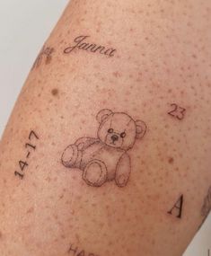 a small teddy bear tattoo on someone's left leg with the date and year