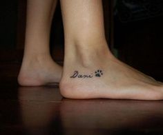 a woman's foot with a dog paw tattoo on her left side and the word paws written in black ink