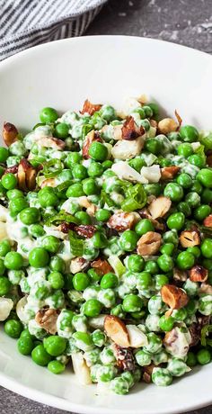 pea salad with almonds and green peas in a white bowl