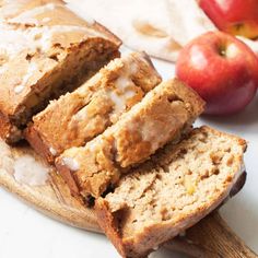 sliced loaf of apple cider bread on a cutting board with apples in the background