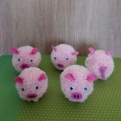 four little pink pigs sitting on top of a green mat