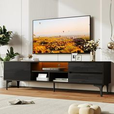 a flat screen tv sitting on top of a wooden entertainment center in a living room