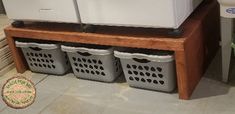 three laundry baskets sitting on top of a wooden shelf next to washers and dryers