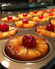 pineapple upside down cupcakes with cherries on top in a muffin tin