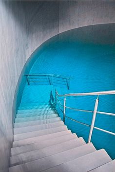 stairs leading up to a pool with blue water