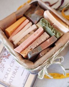 a box filled with different types of soaps on top of a table next to a book