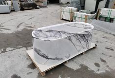 a large white marble slab sitting on top of a wooden pallet in a warehouse