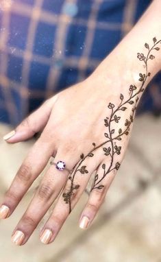 a woman's hand with a flower tattoo on it