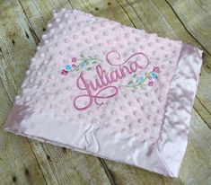 a pink blanket with embroidered name on it