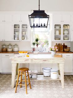 a kitchen with white cabinets and wooden stools