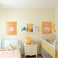 a baby's room with two cribs and pictures on the wall