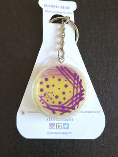 a keychain with a yellow and purple design on it's front end