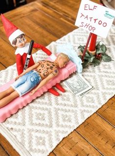 an elf is laying on top of a fake man in the middle of a table