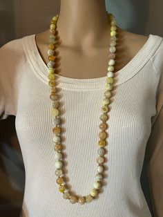 Long Fire Agate gemstone long necklace. 12 mm round faceted beads, every bead is unique in color and translucency. Gold plated spacer beads and AB rhinestone spacers.  Necklace is 38" long, antique gold toggle clasp. Can be wrapped twice around the neck. Please, keep in mind that the mannequin shown is smaller than an average person.  Ready to ship in a gift bag. Thanks for looking and have a great day! Yellow Gemstone Necklace, Thanksgiving Jewelry, Average Person, Yellow Gemstones, Fire Agate, Gift For Woman, Chunky Necklace, Beads Necklace, Agate Gemstone